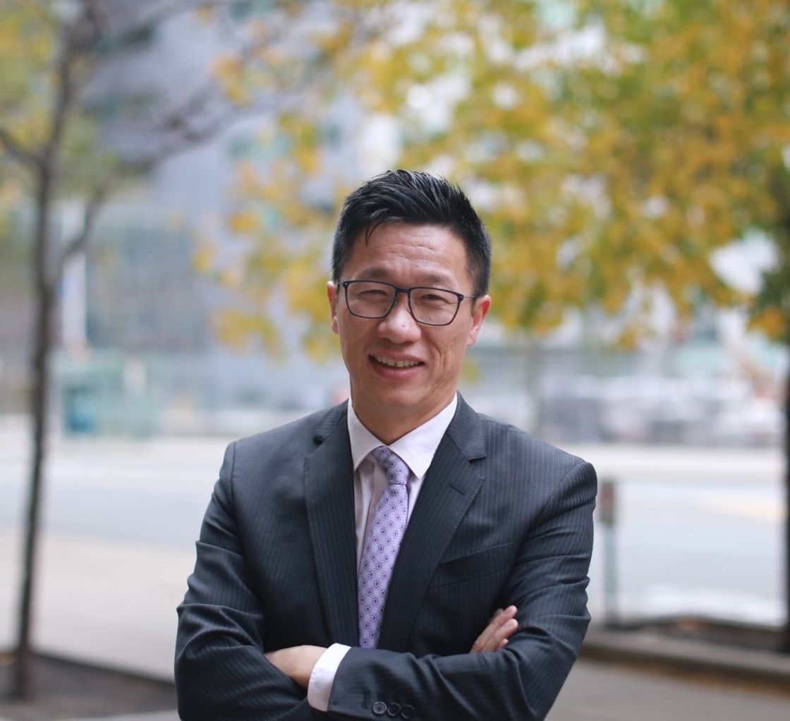 Jobi Wong sitting at desk doing financial planning
